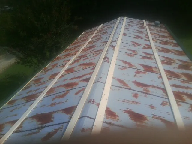 Rusted metal roof panels with new wood purlins before replacement — Storm Damage Roof Repair in Little Chute by Roofing Brothers