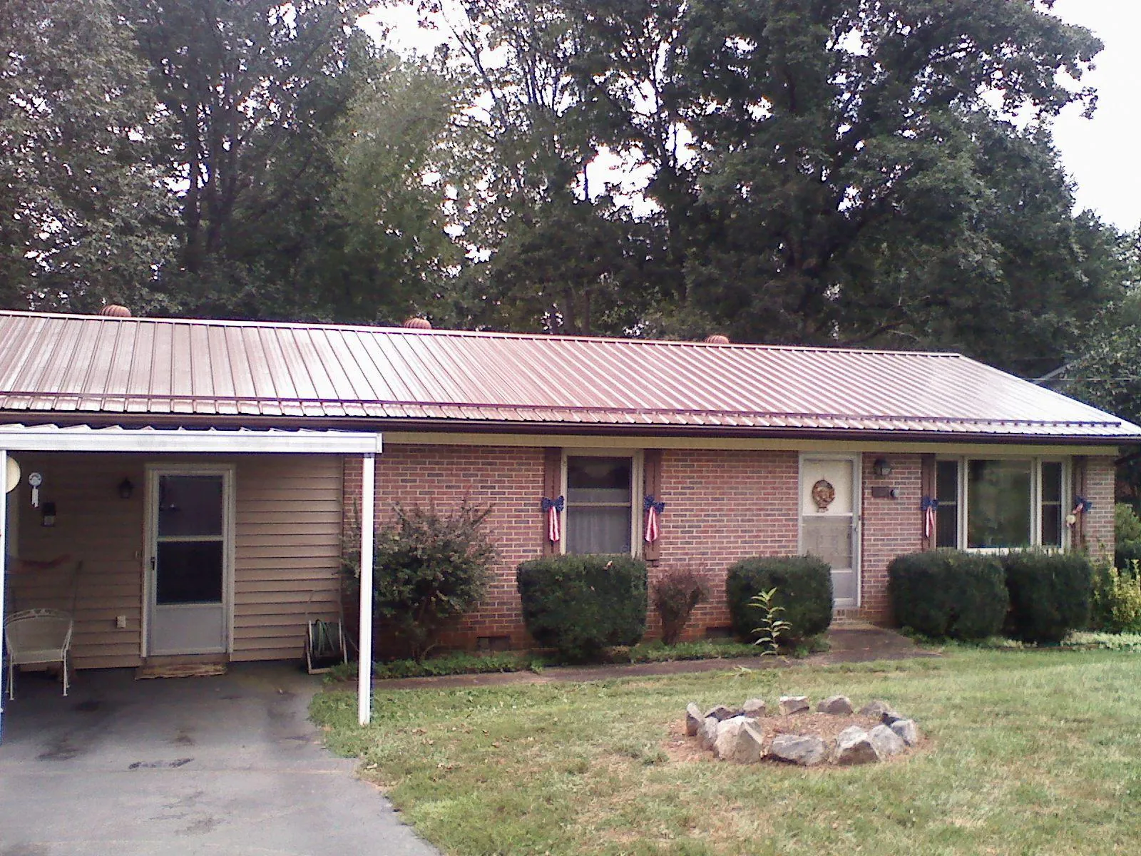 Bronze metal roof and carport on a brick ranch home — Roof Repair work by our crew in Little Chute