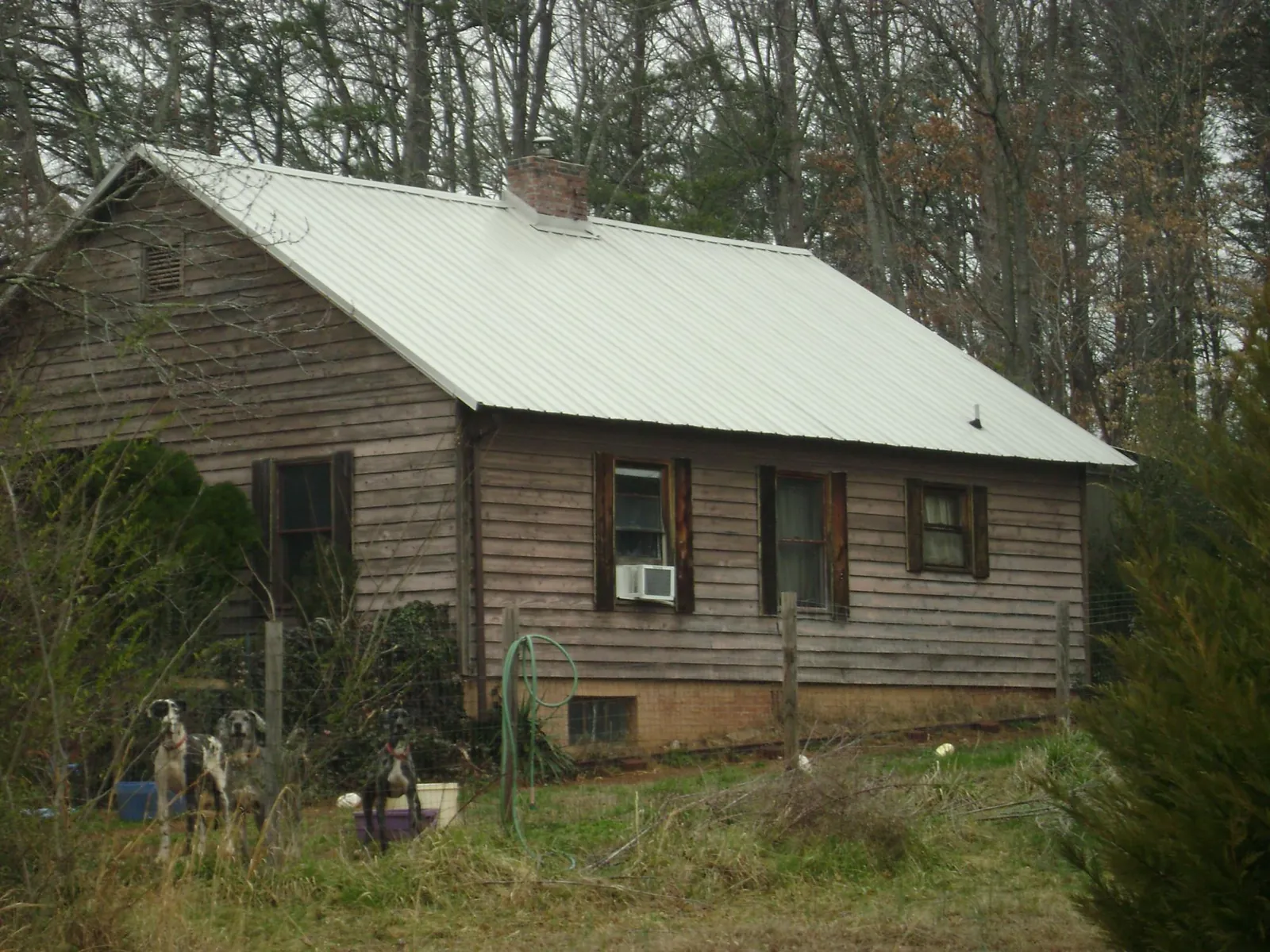White metal roof on an old wood sided farmhouse, from a Metal Roof Installation job in Little Chute